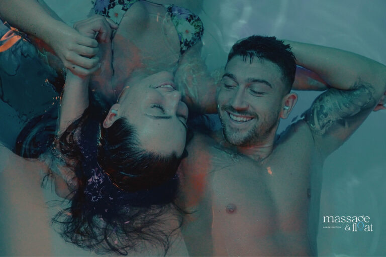 Man and woman looking at each other while in a float therapy tank